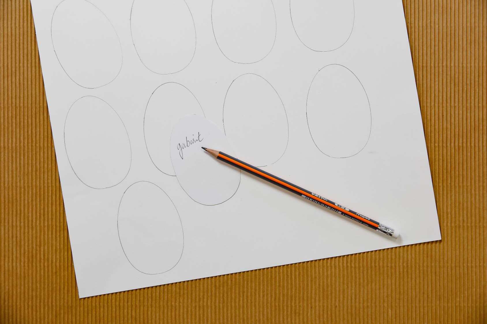 A white page with hand drawn eggs next to a pencil