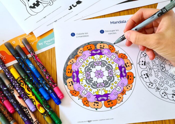 A hand colouring in a Halloween activity sheet
