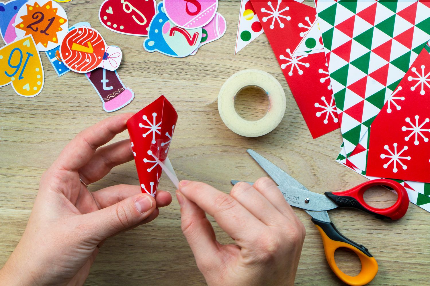 A hand applying tape to a coloured pouch