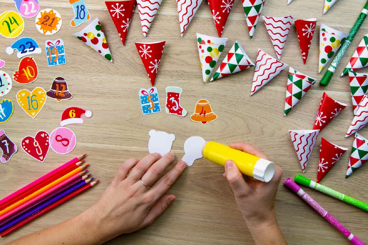 A hand applying glue to the back of numbered labels