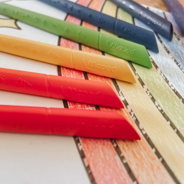 A close up picture of a rainbow colouring with infinity colouring pencils on top of the paper