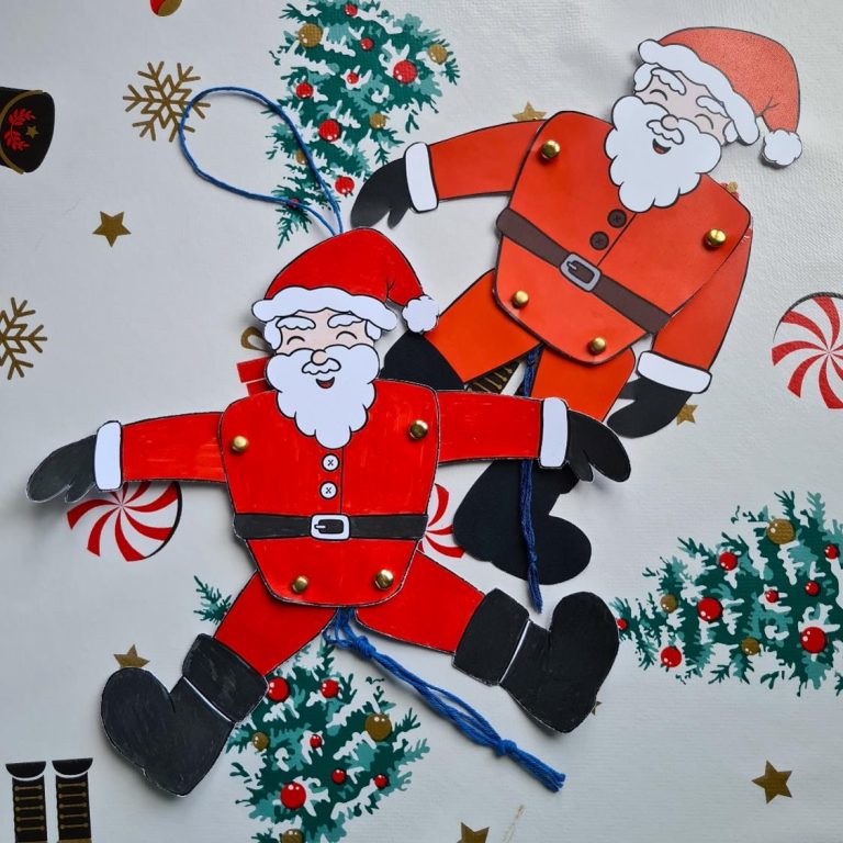 Two Santa puppets lay on a Christmas themed table cloth