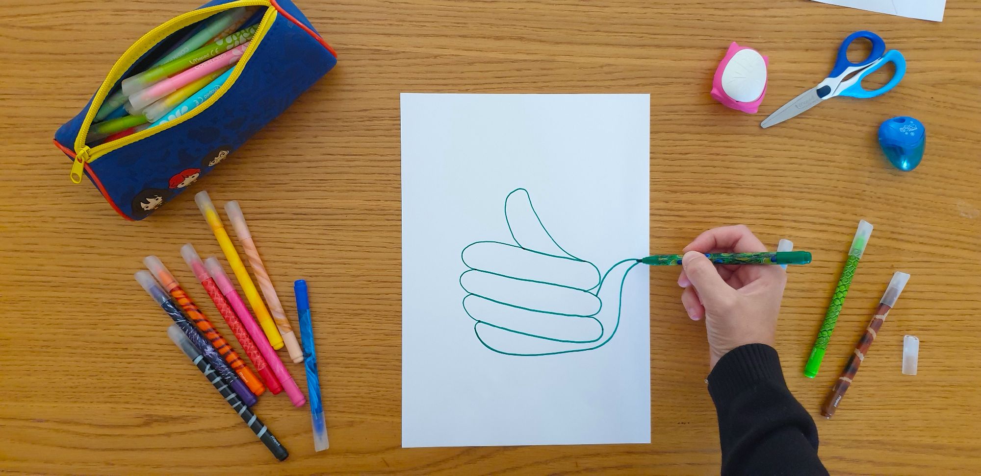 A picture of the outline of a snake on a piece of paper laying on a desk