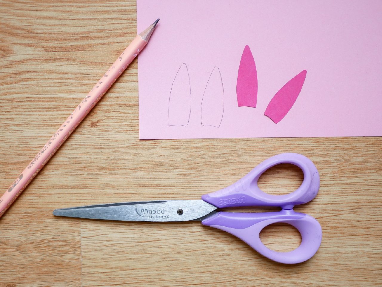 a pair of scissors and some coloured paper on a desk