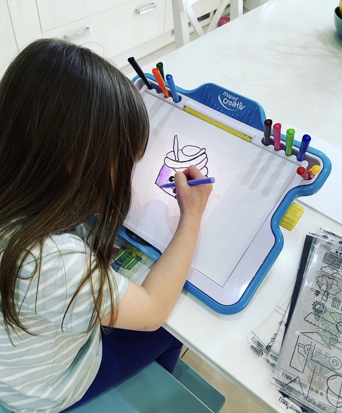 girl drawing a cupcake on the lumi board