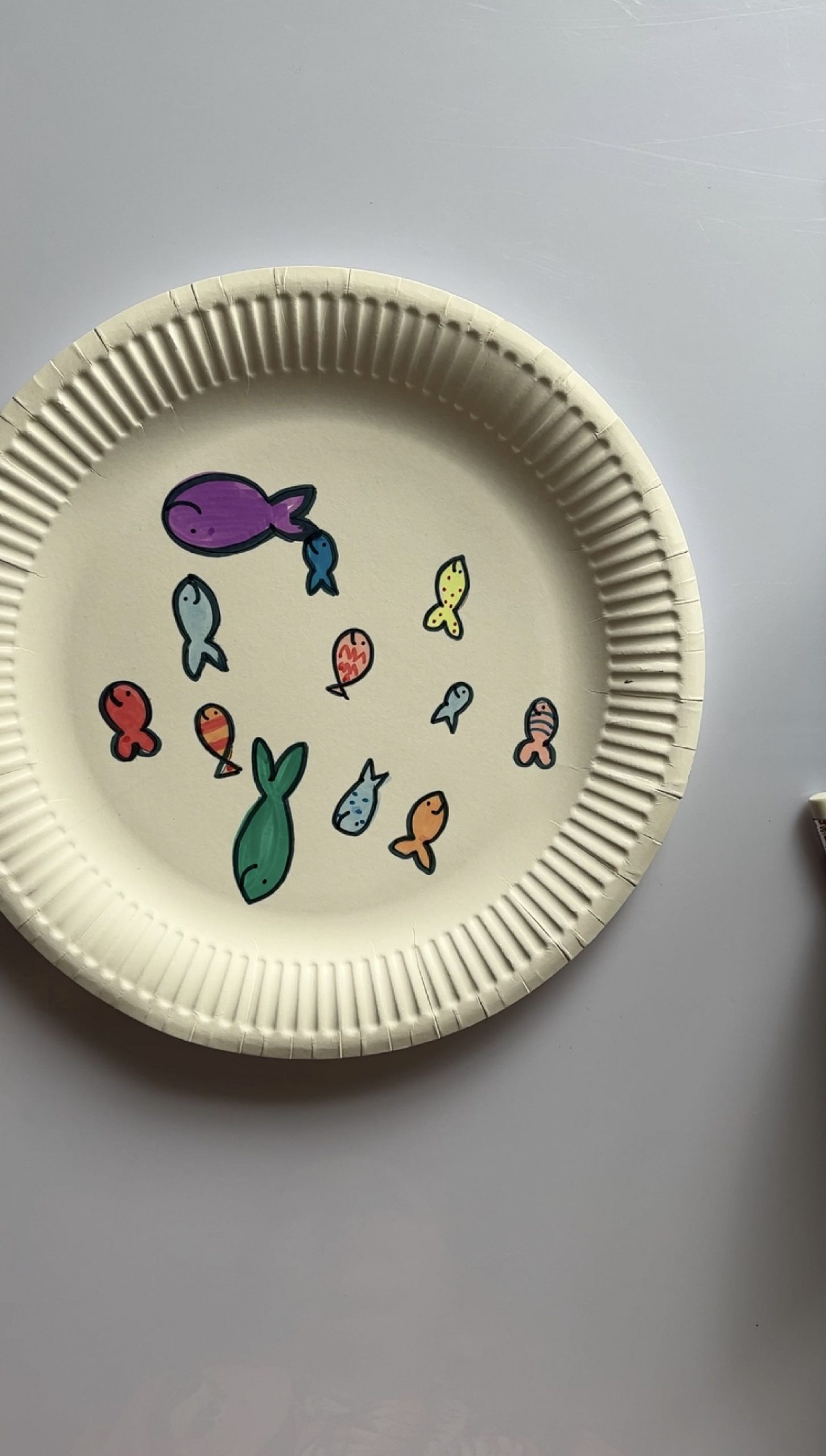 Colourful fish drawn on a paper plate
