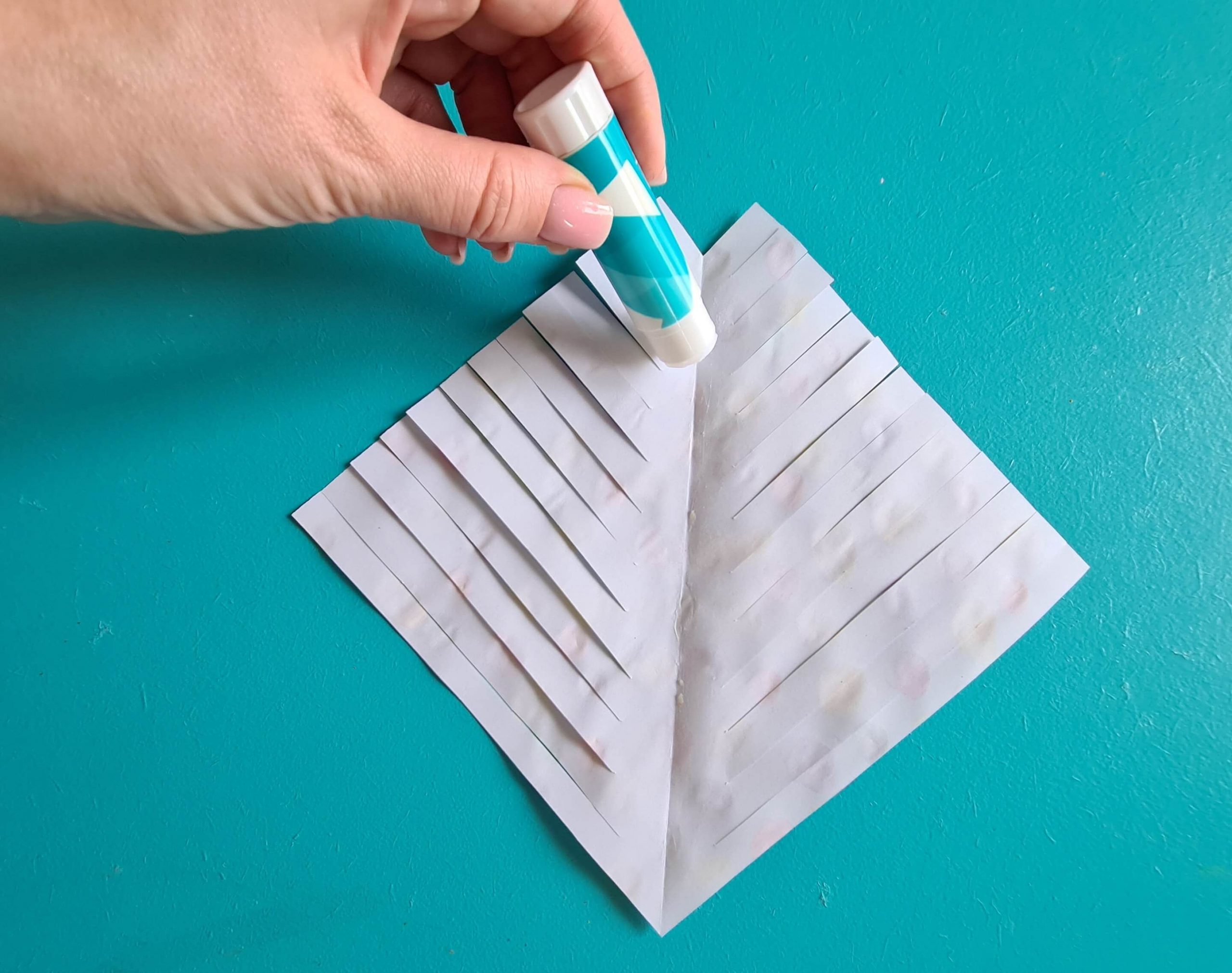 applying glue to the back of the paper