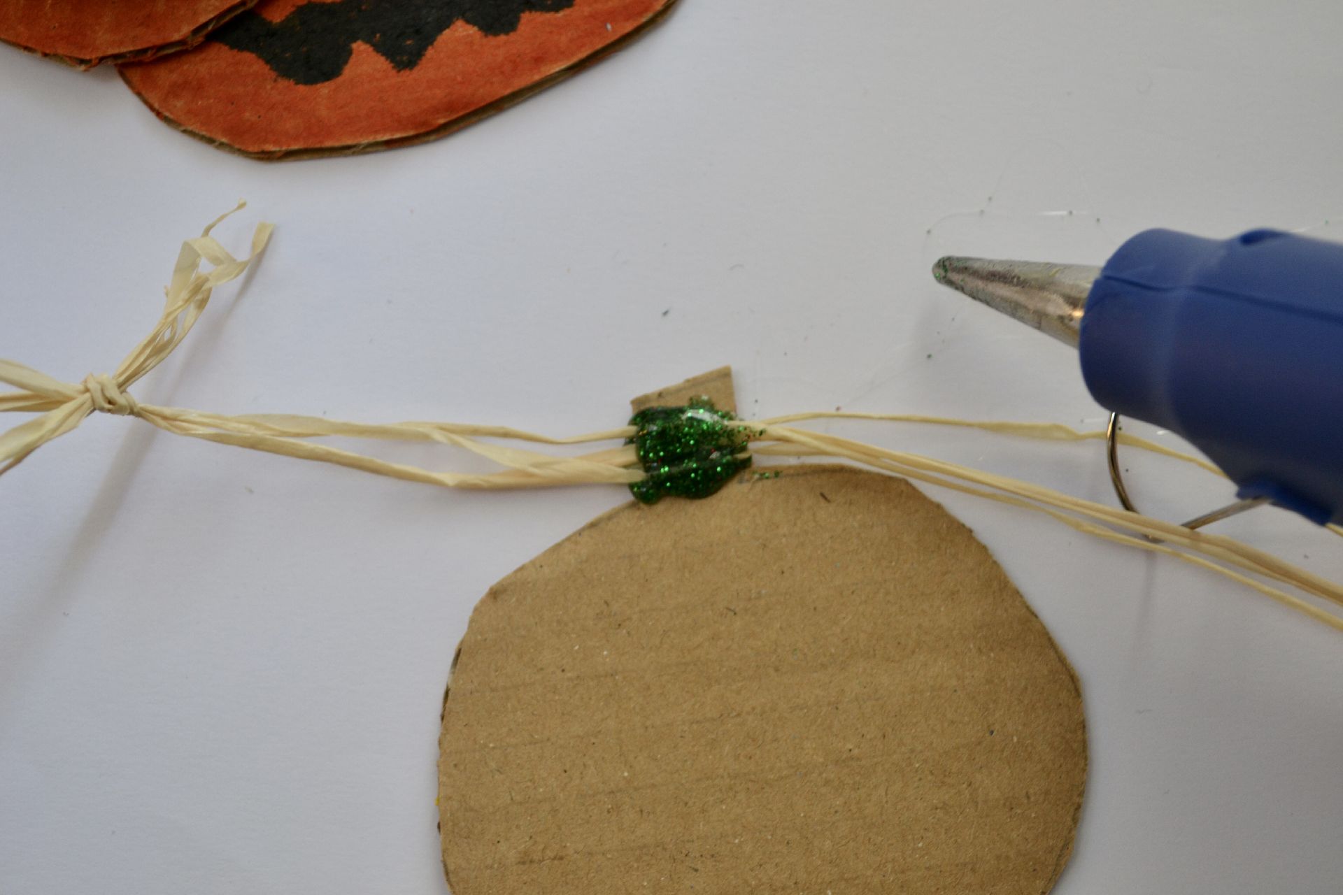 a piece of string attached to the back of the cardboard pumpkin