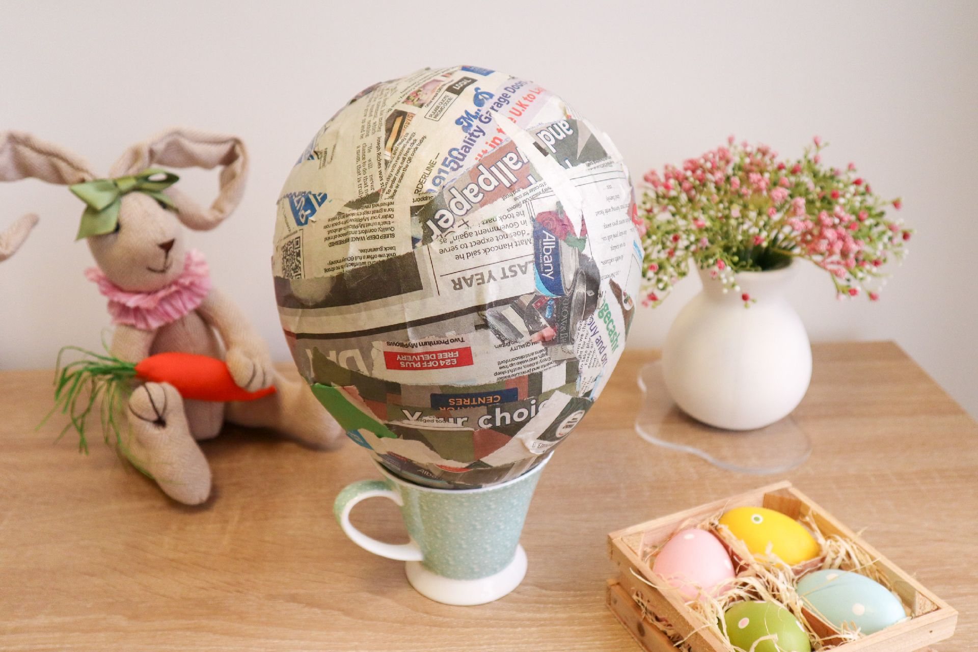 An inflated balloon entirely covered with strips of newspaper and PVA glue