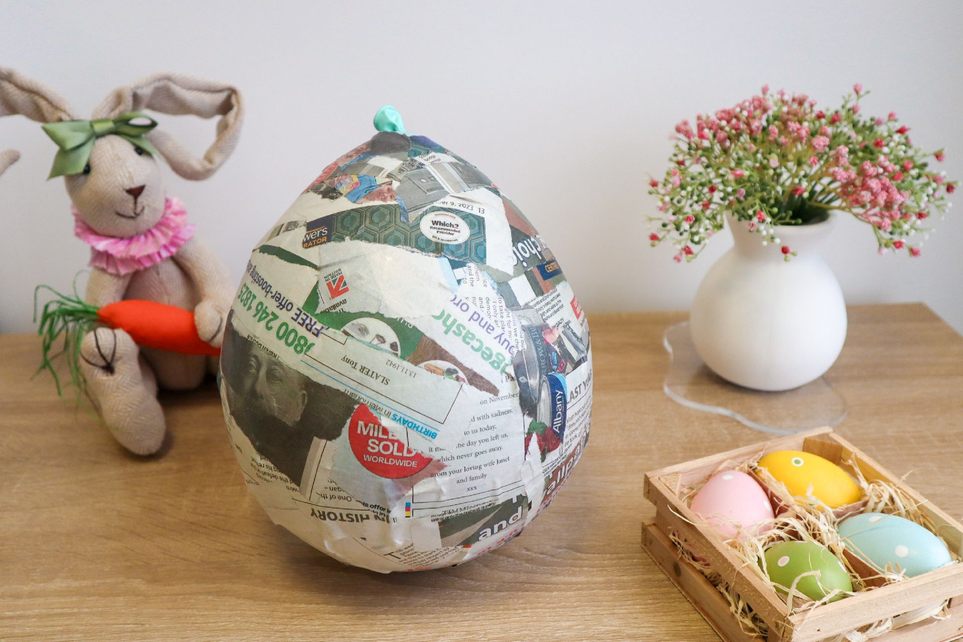 An inflated balloon entirely covered with strips of newspaper and PVA glue