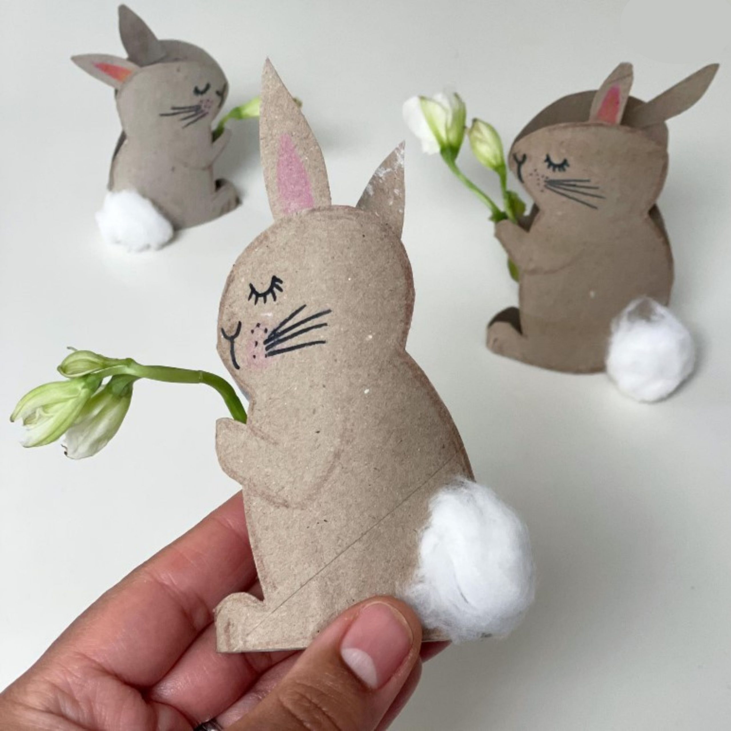 bunnies made from cardboard holding flowers