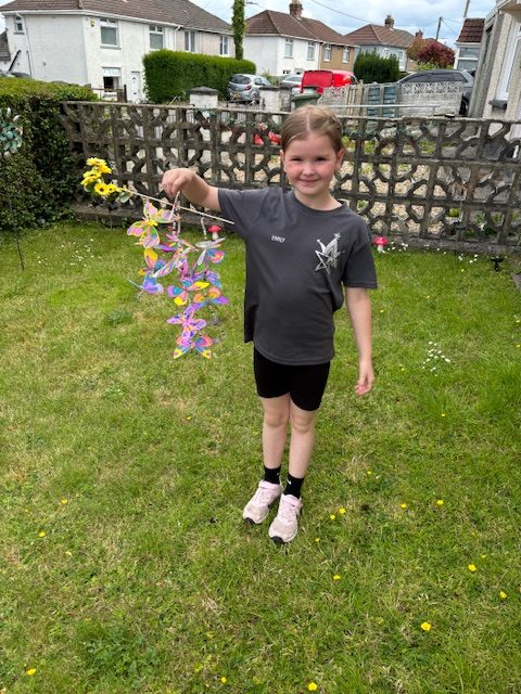 Emily holding the butterfly mobile that she made