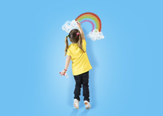 Girl colouring a rainbow on a blue background